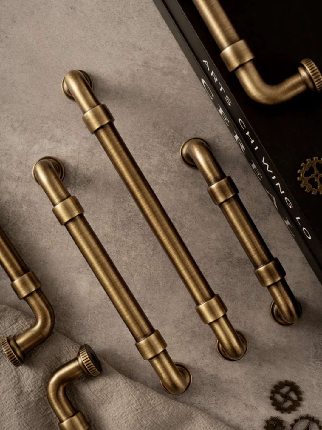Set of brass pipe-style cabinet handles on a textured surface