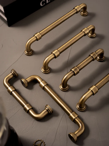 Set of vintage-style brass handles on a dark surface
