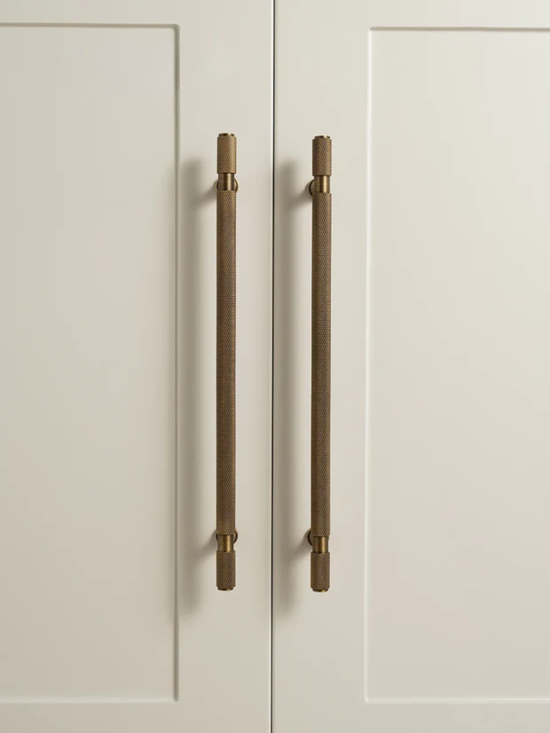 Cabinet doors with bronze handles on a light gray background
