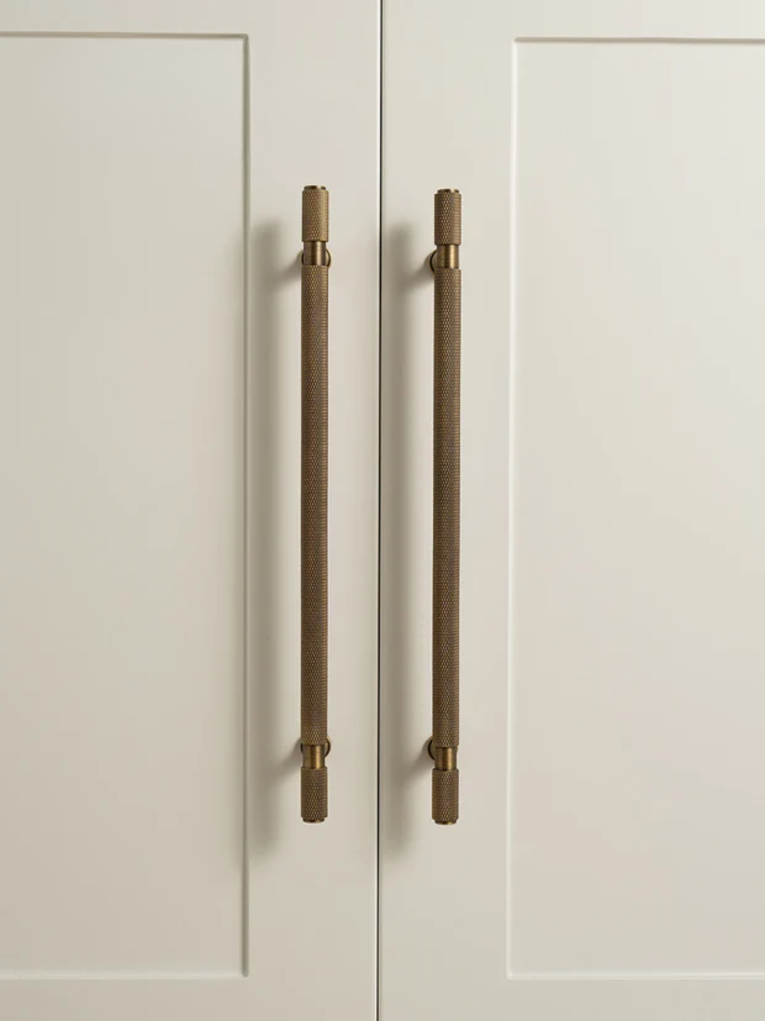 Cabinet doors with bronze handles on a light gray background