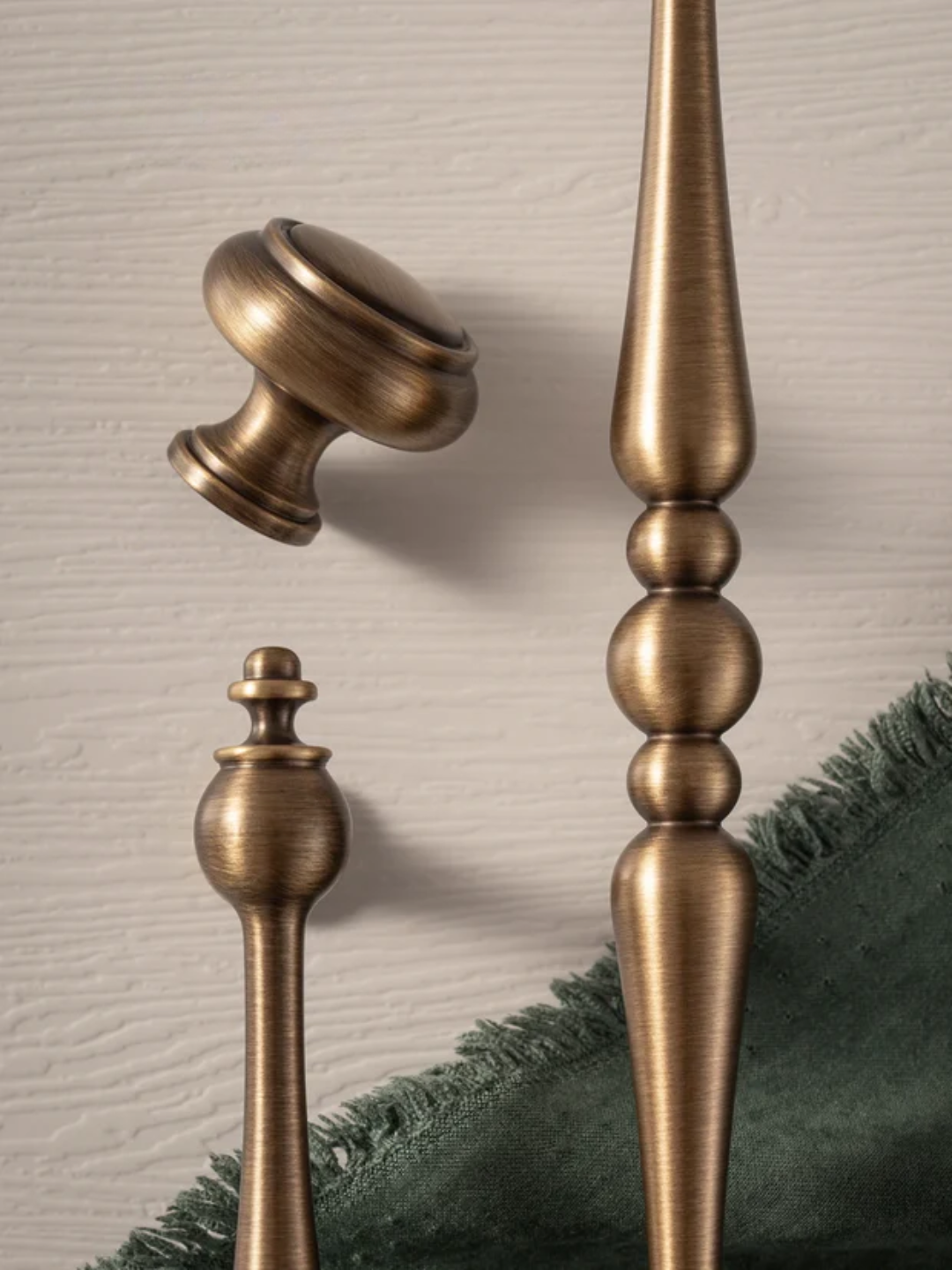 Bronze decorative finials on a textured beige background.