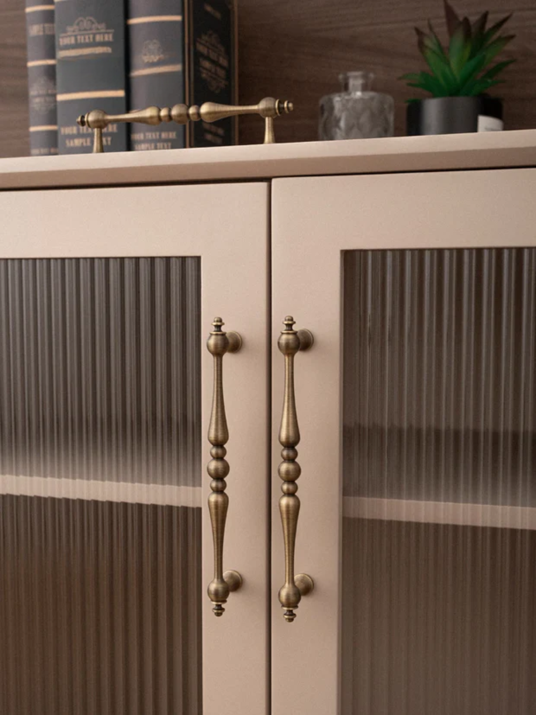 Cabinet with glass doors and brass handles in a home setting