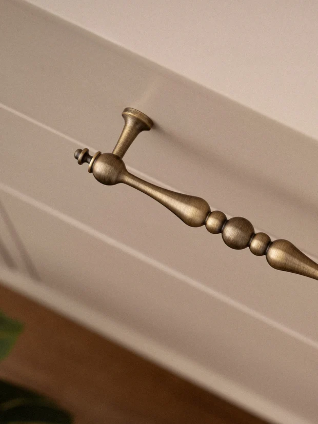 Close-up of a decorative brass handle on a wooden surface