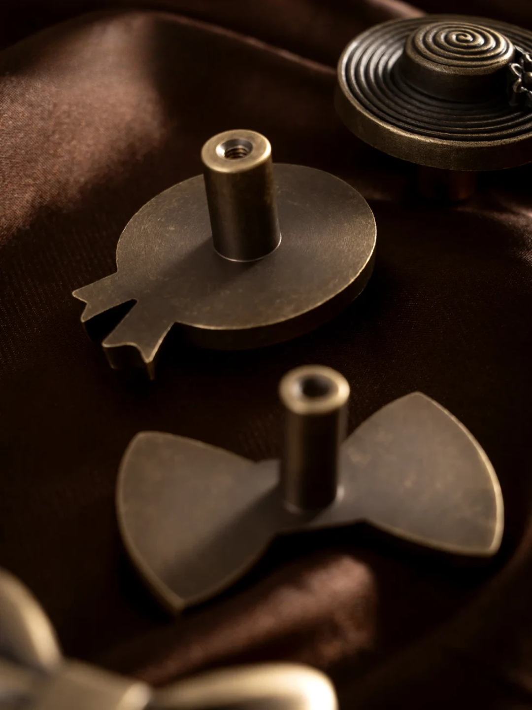 Bronze bow tie and other decorative items on a dark surface