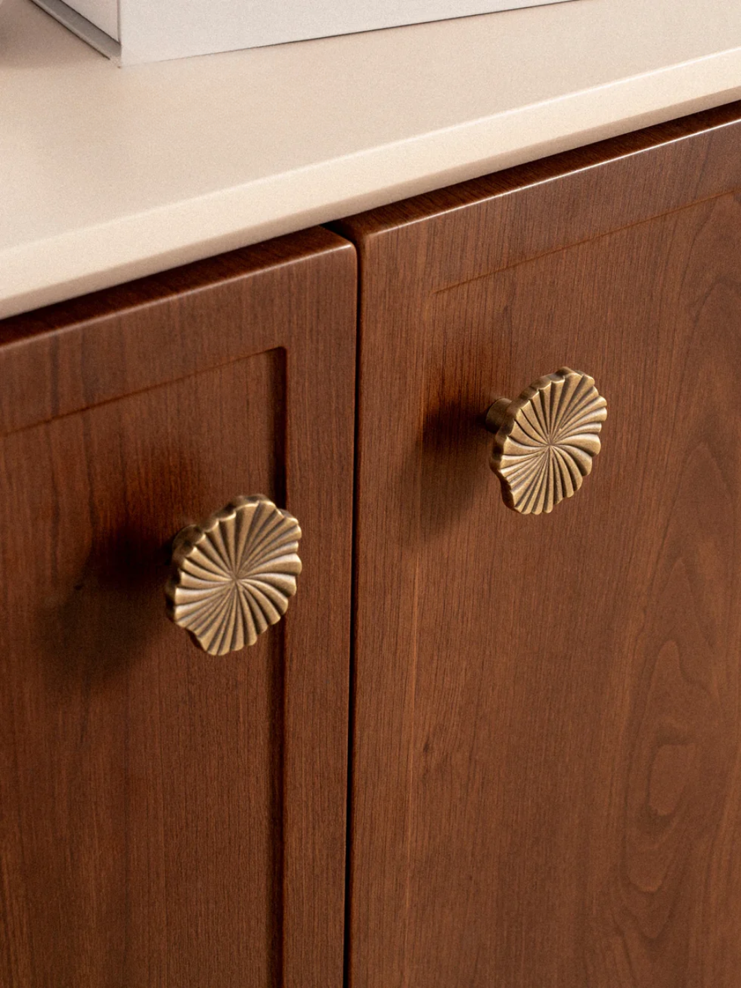 Wooden cabinet with brass knobs on a neutral background