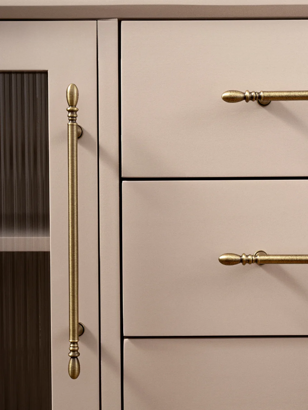 Close-up of beige kitchen cabinets with gold handles