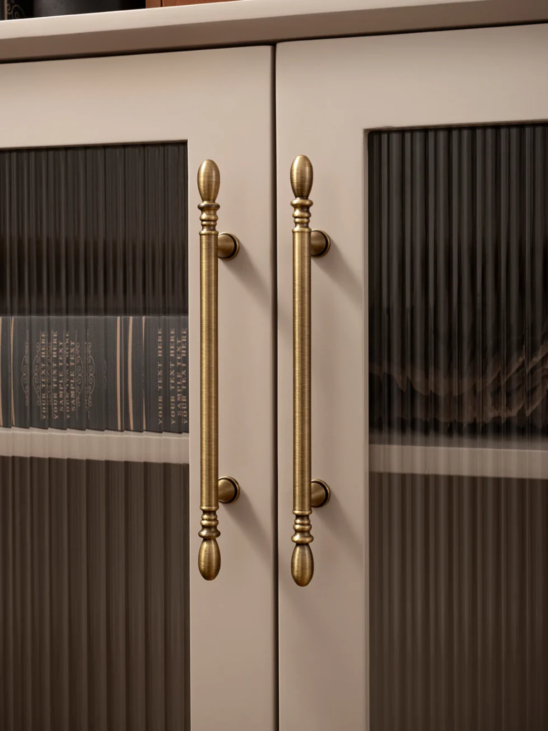 Close-up of a cabinet with glass doors and gold handles.