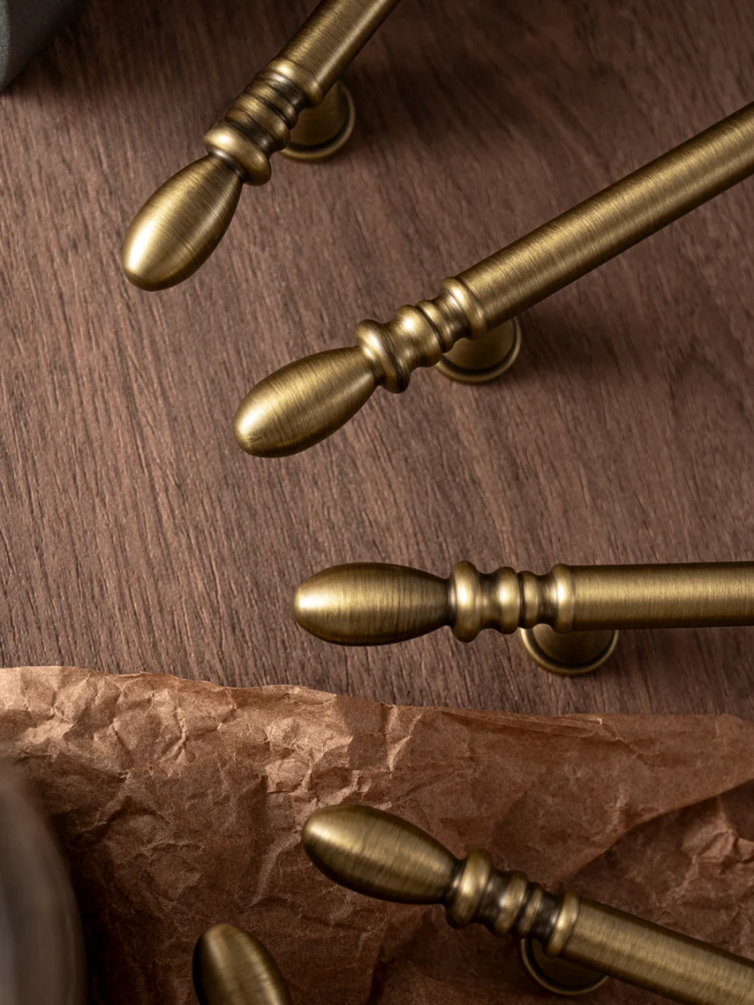Close-up of gold curtain rods on a wooden surface