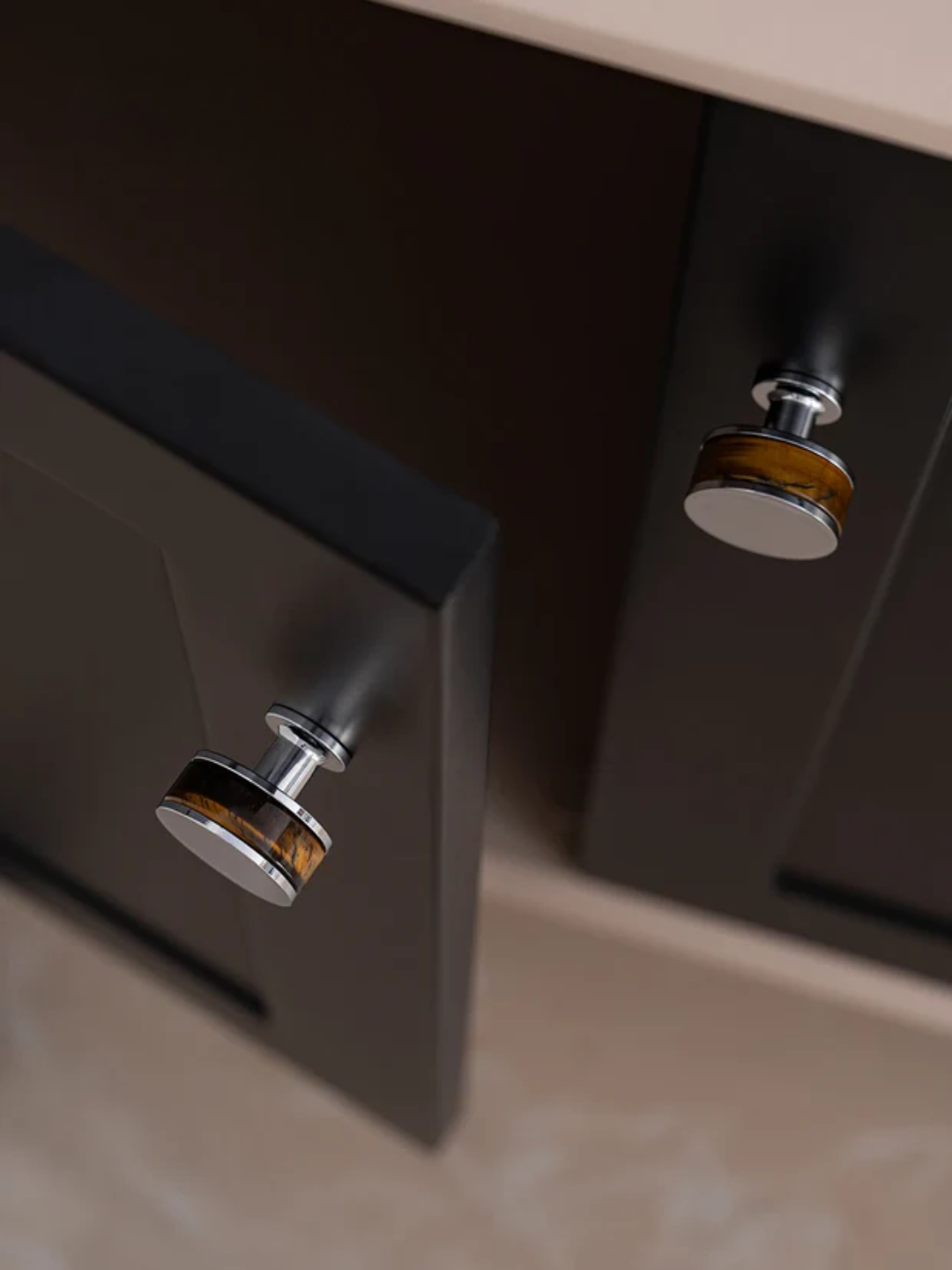 Close-up of metallic cabinet handles on a wooden cabinet.