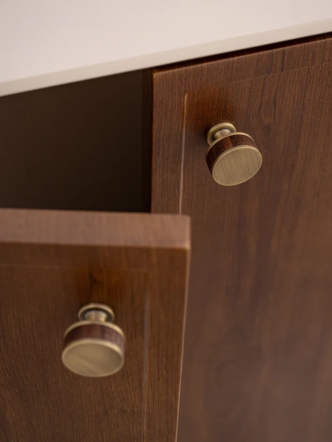 Wooden cabinet with round knobs on a white background