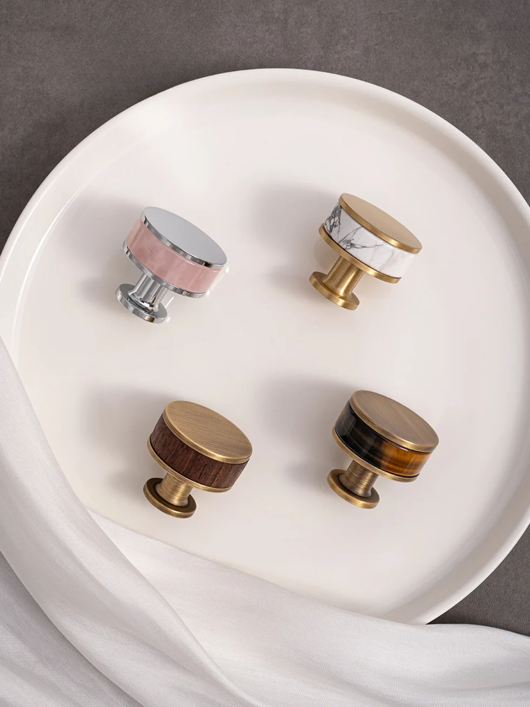 Set of decorative cabinet knobs on a white plate with a gray background