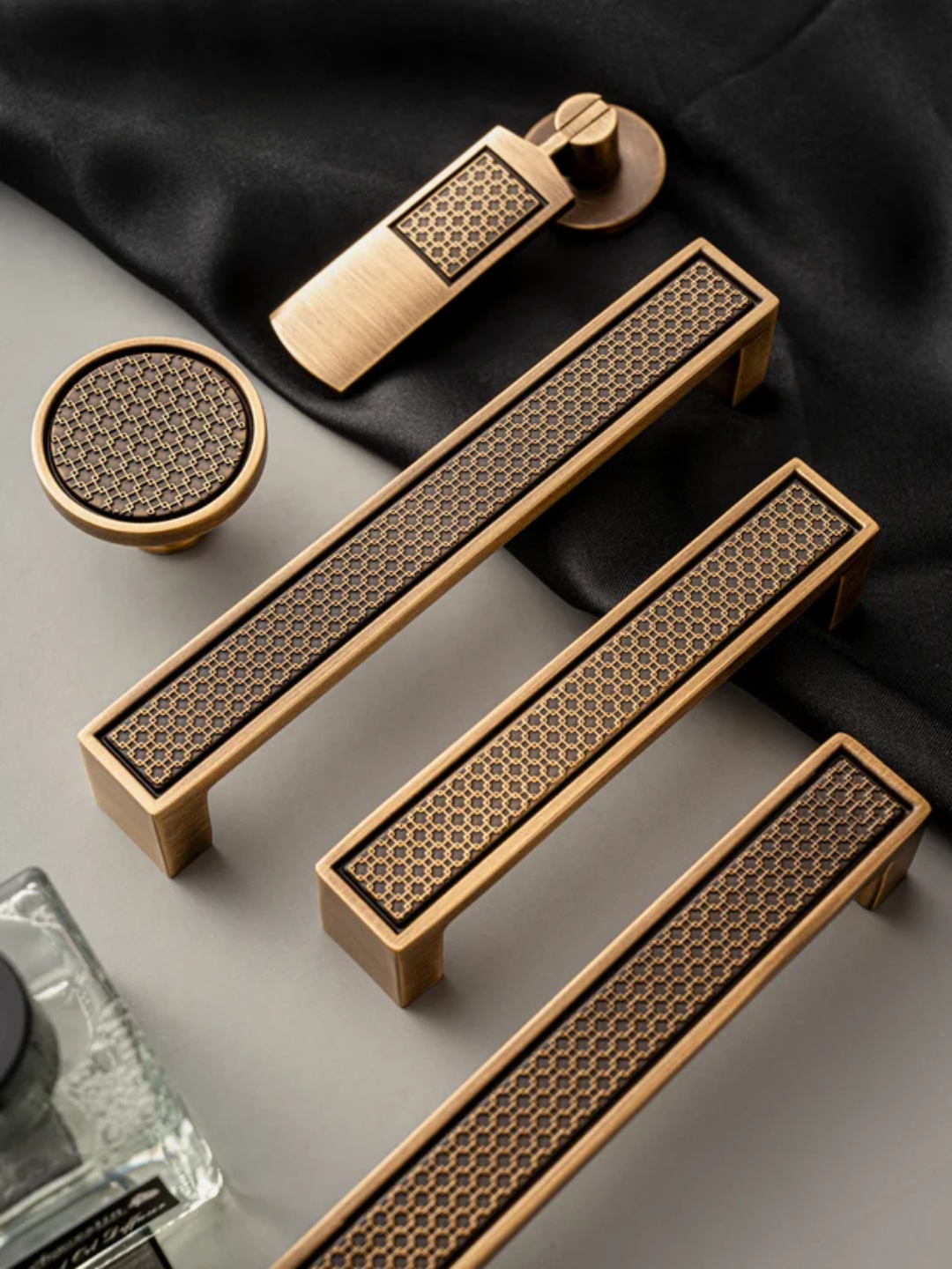 Set of bronze cabinet handles on a dark fabric background