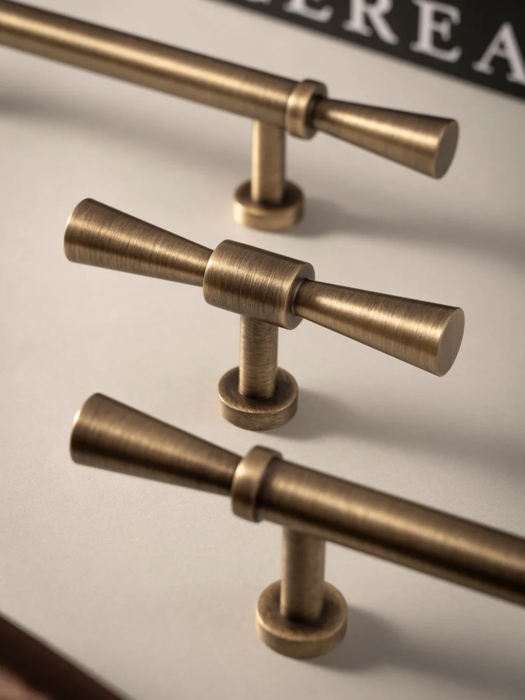 Close-up of brass cabinet handles on a neutral background