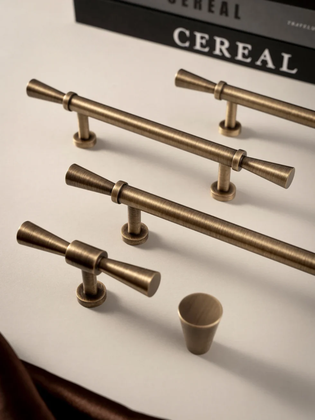 Bronze cabinet handles on a neutral background with 'Santaya' branding.