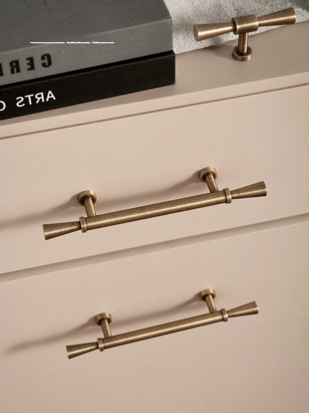 Beige dresser with gold handles on a neutral background