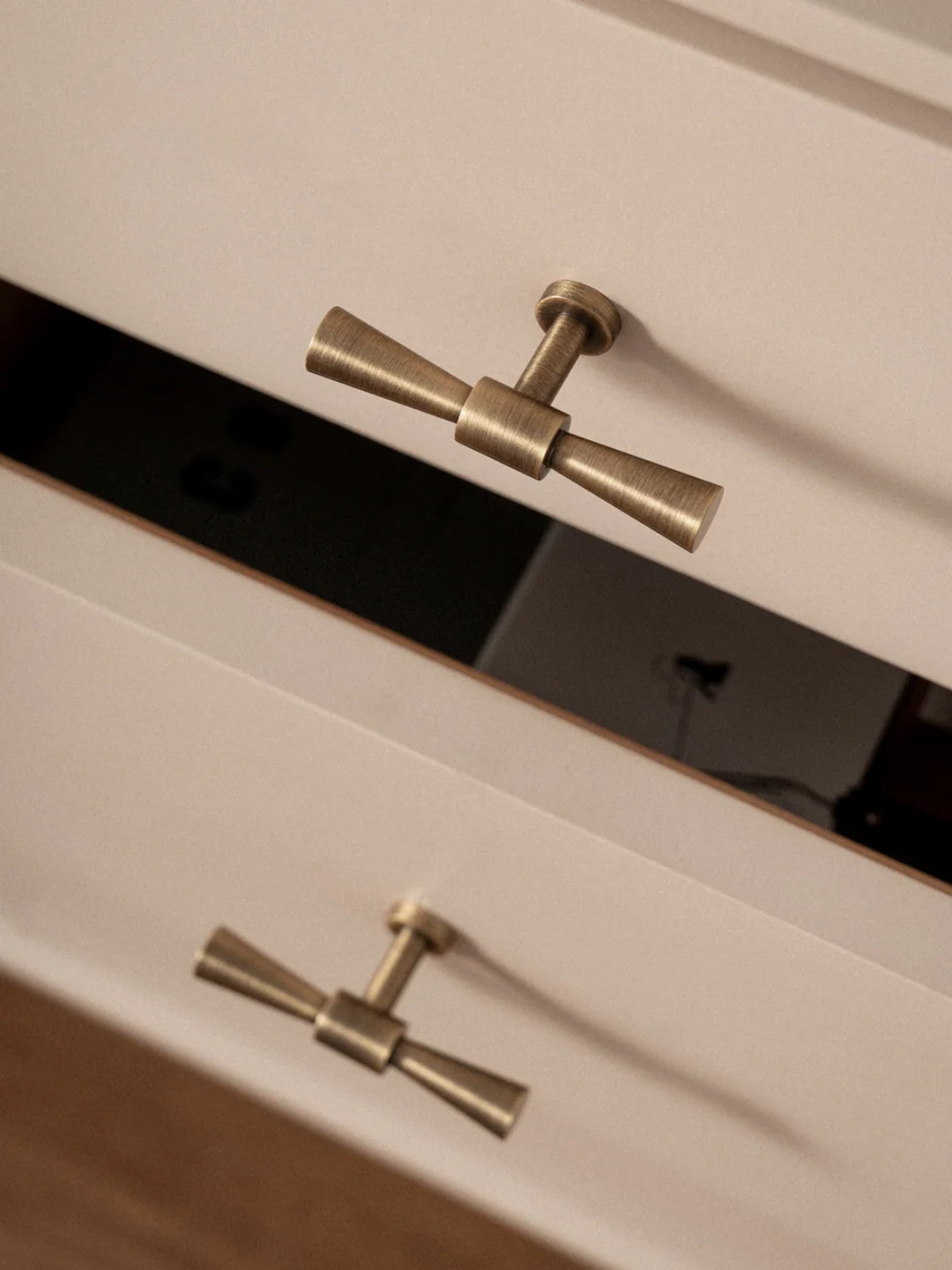 Close-up of a cabinet with brass handles on a neutral background