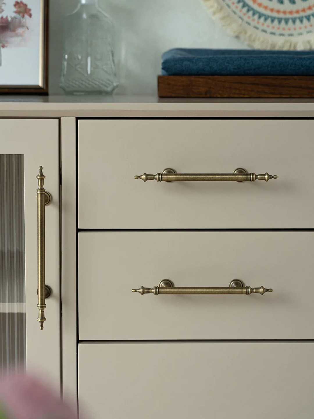 Cabinet with brass handles on a neutral background
