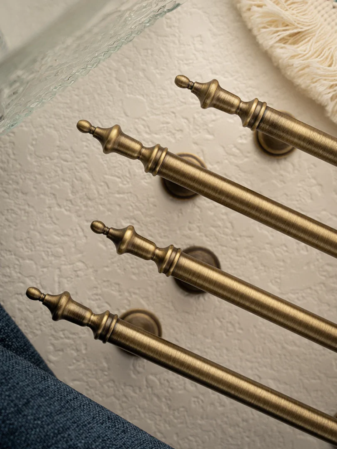 Set of gold decorative curtain rods on a textured surface