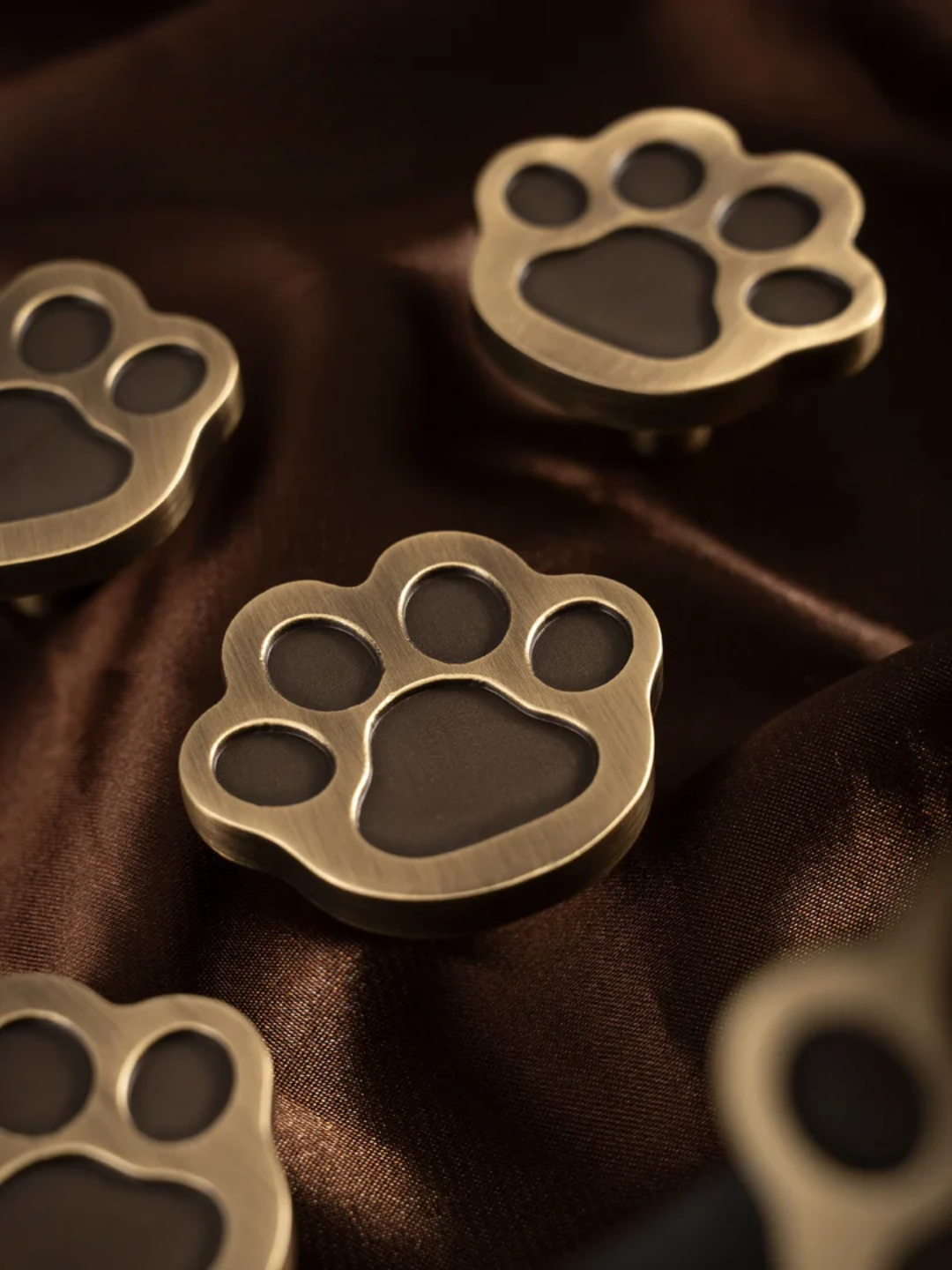 Bronze panda-shaped earrings on a neutral background