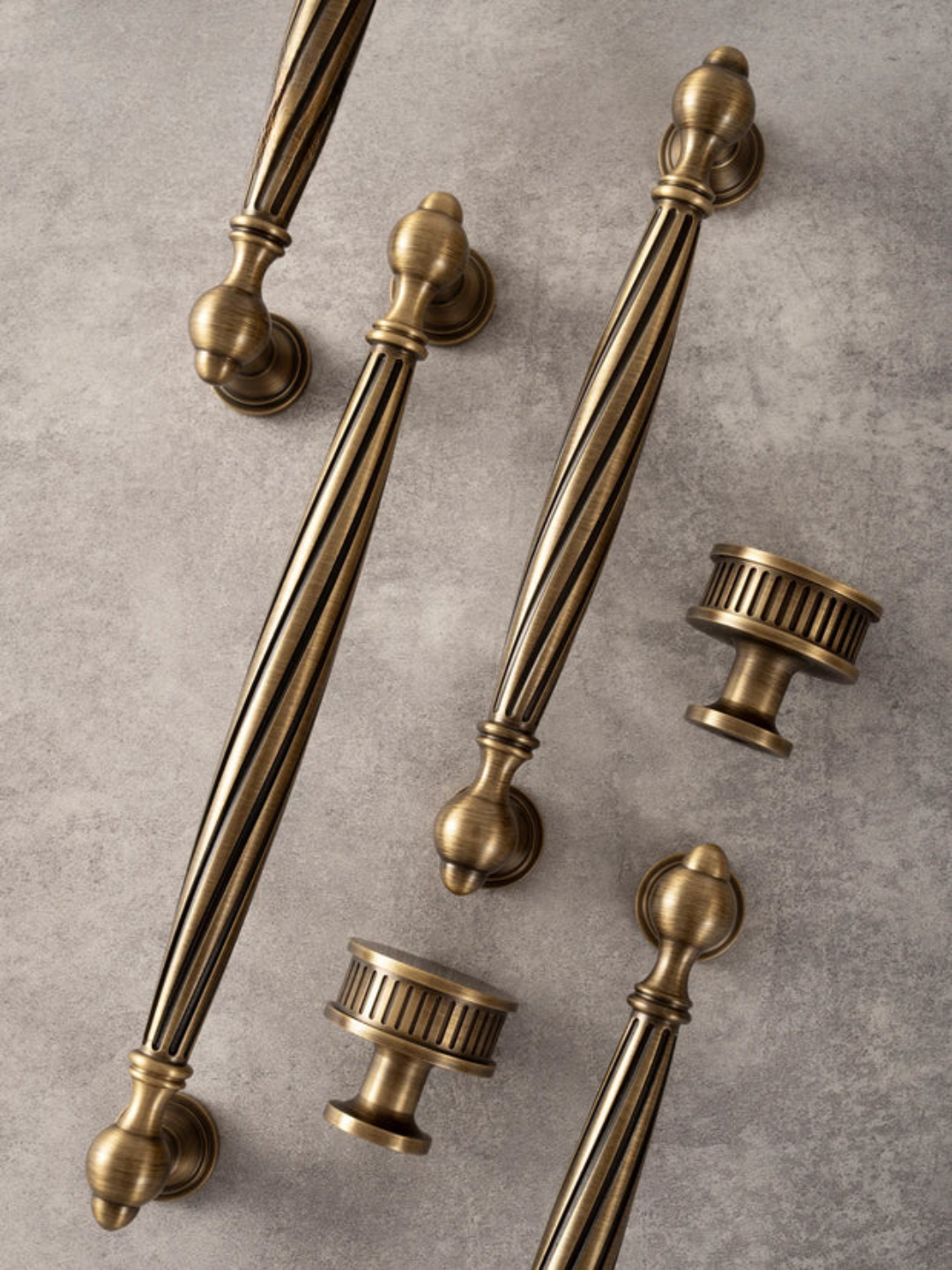Set of vintage-style brass cabinet handles on a textured surface