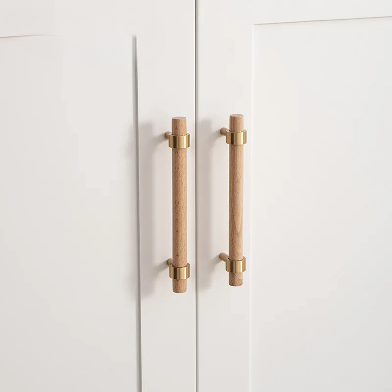 White cabinet with wooden and brass handles on a white background