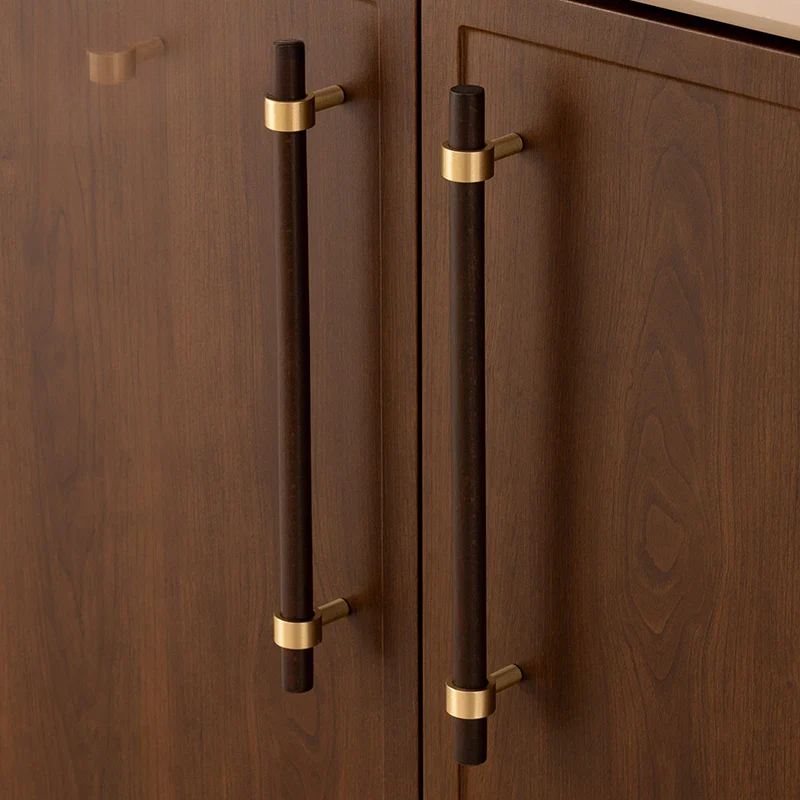 Wooden cabinet doors with dark brown handles and gold accents