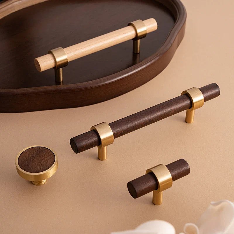 Wooden cabinet handles with gold accents on a beige surface