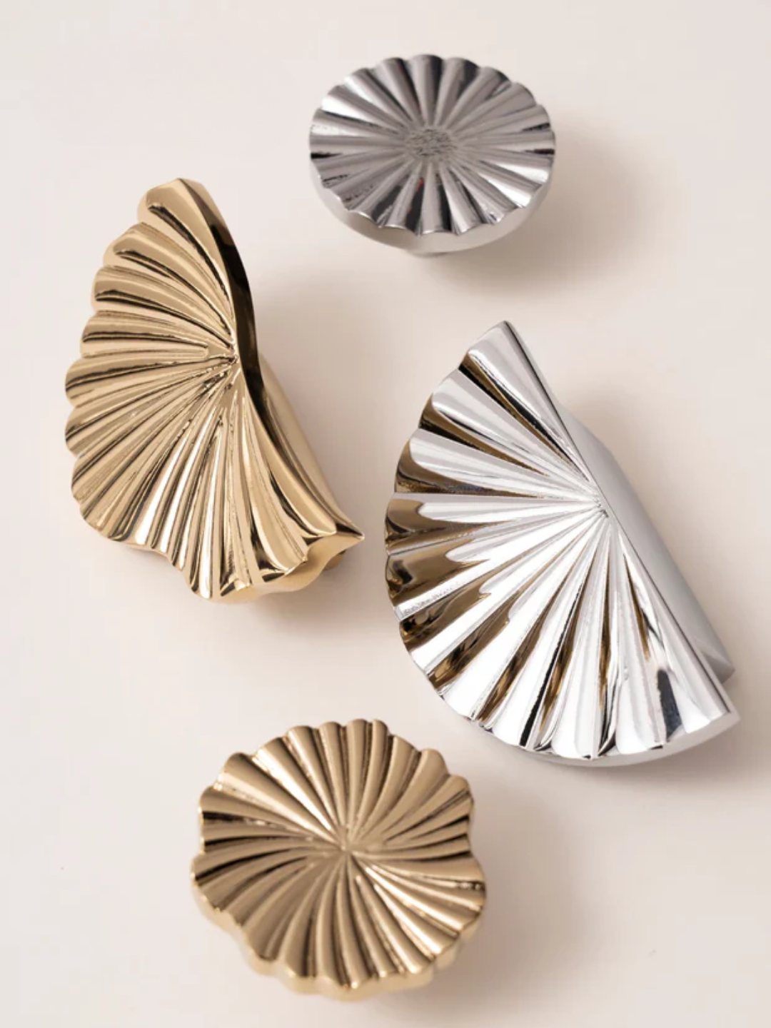 Decorative wall art pieces in gold and silver on a light background