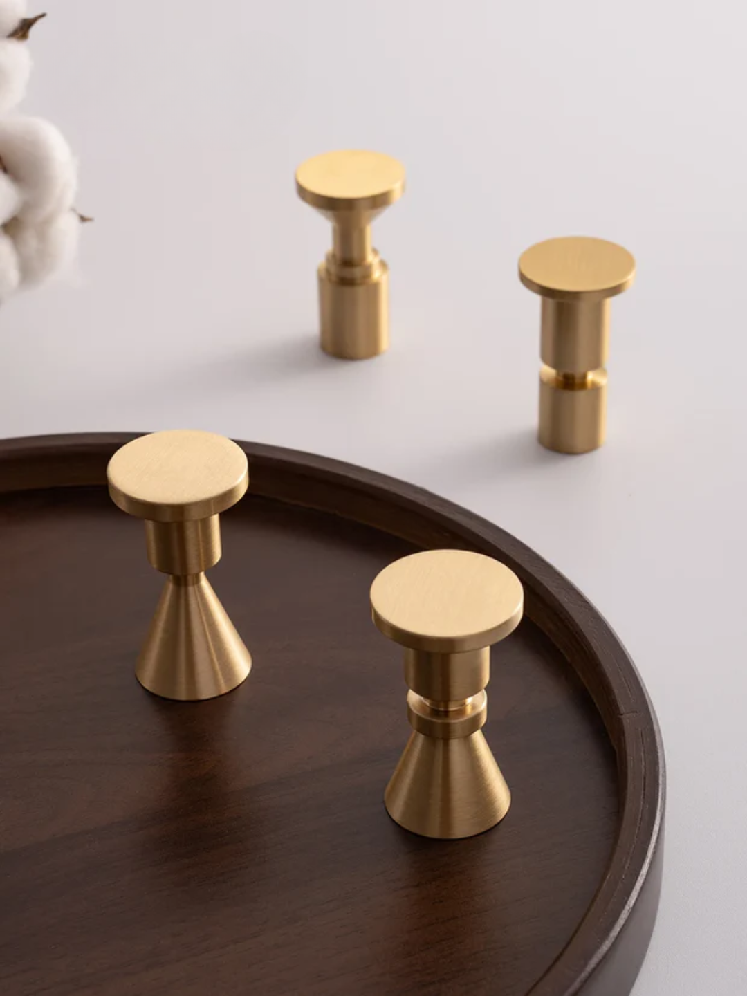 Gold cabinet knobs on a wooden tray with 'Santaya' branding.