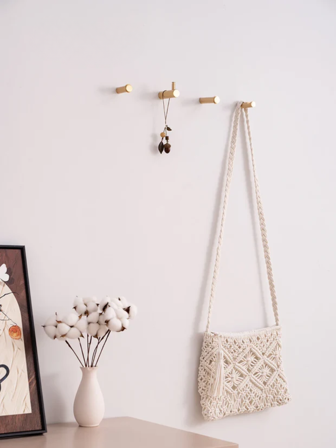 Macrame bag hanging on a hook with a white wall background, featuring the Santaya brand.