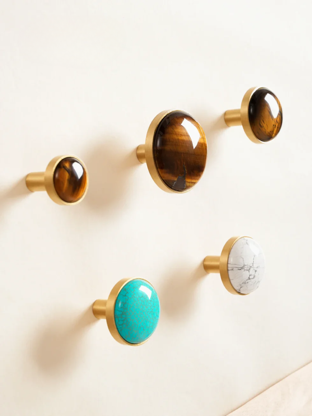 Set of decorative cabinet knobs with turquoise, marble, and wooden finishes on a white surface.