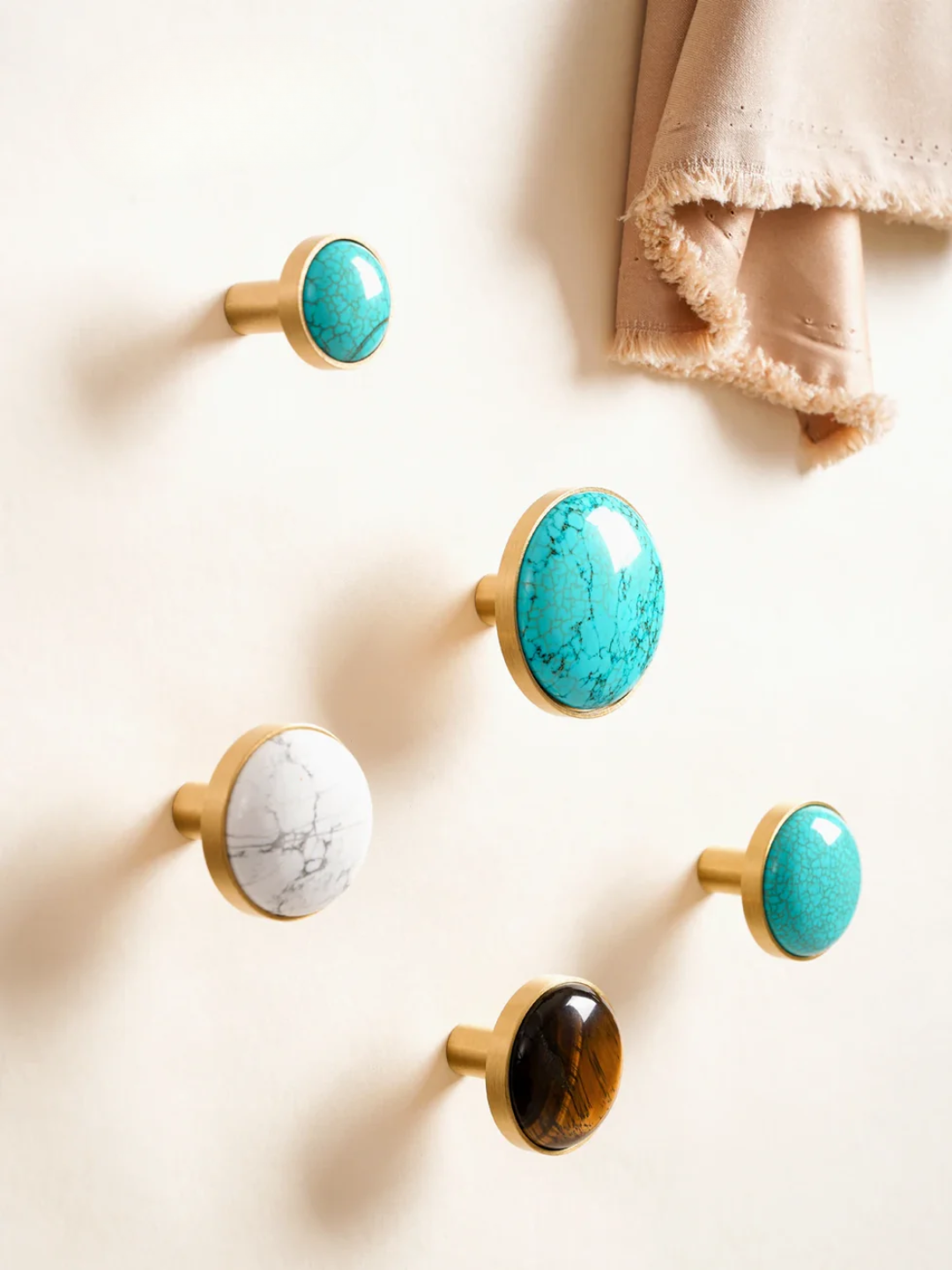 Set of decorative cabinet knobs with turquoise, marble, and wooden finishes on a white surface.