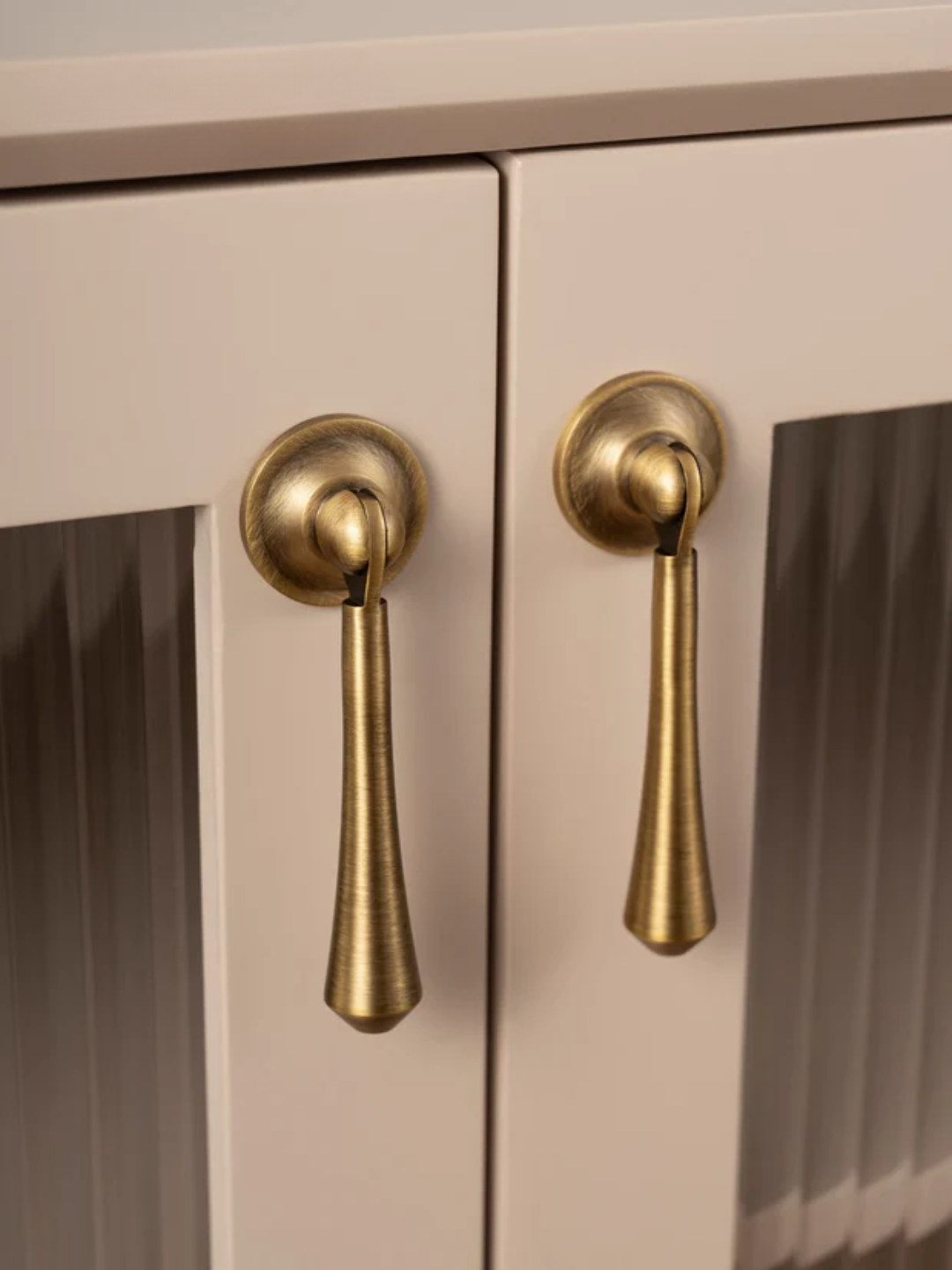 Close-up of beige cabinet doors with gold handles