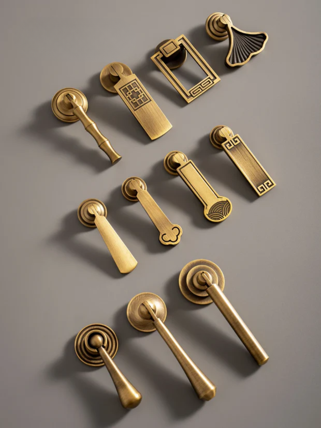 Collection of gold door handles and hardware on a gray background