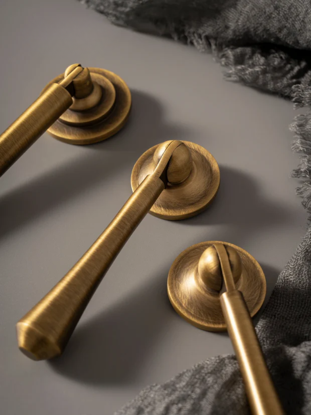 Close-up of gold door handles on a textured surface