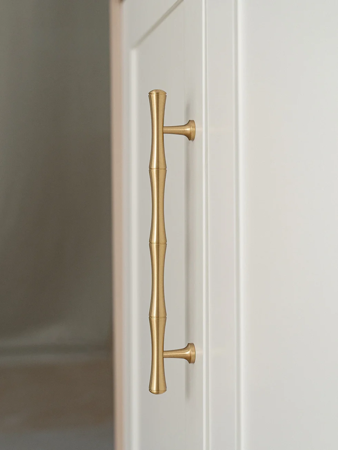 Close-up of a gold door handle on a white door