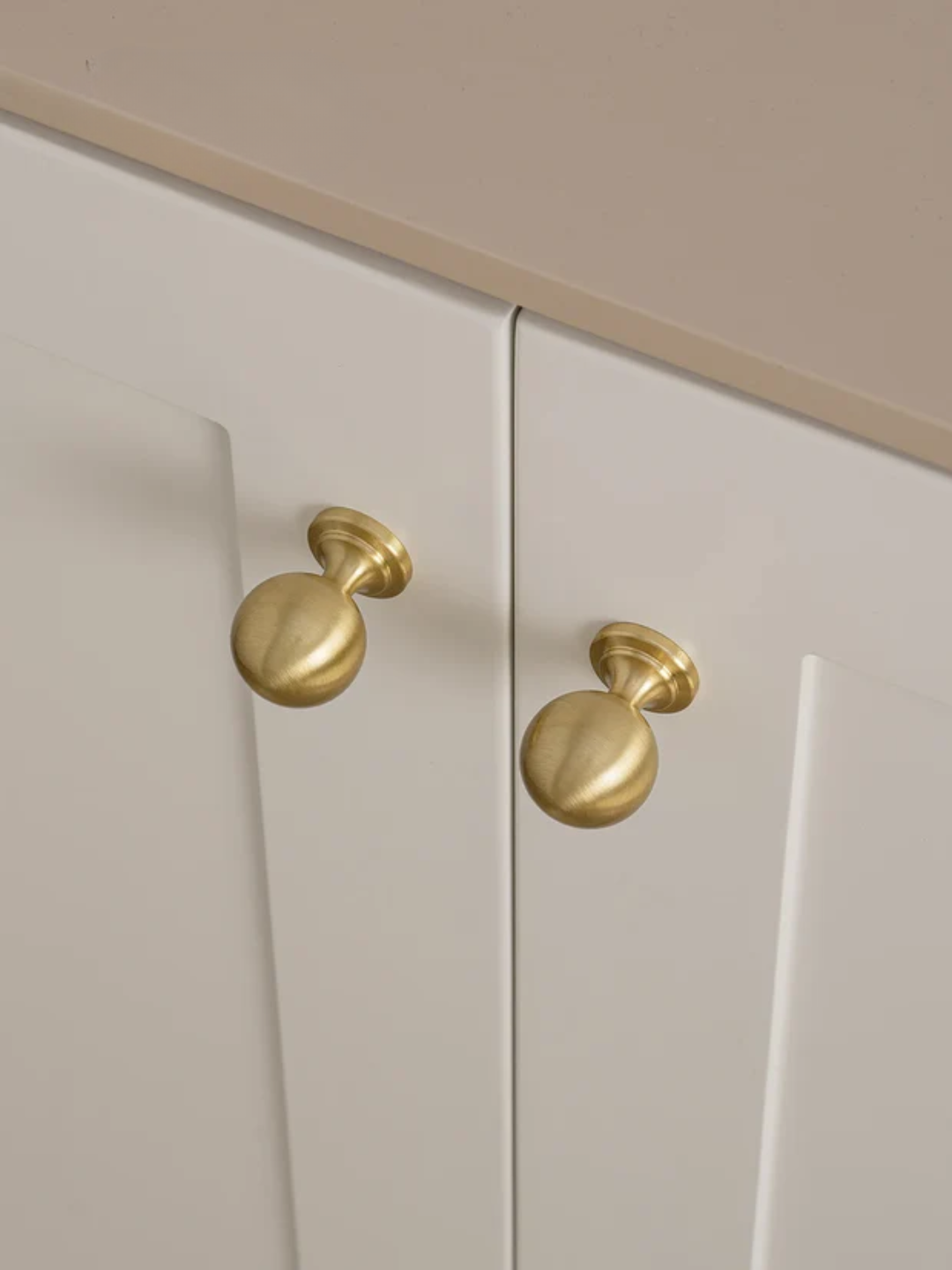 Close-up of beige cabinet doors with gold handles