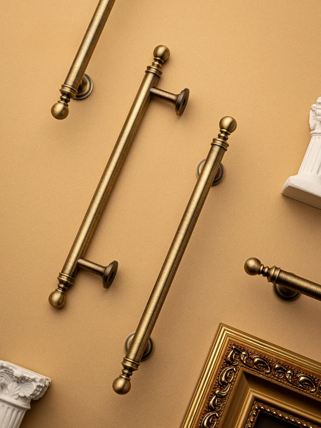 Gold decorative elements including handles and a frame on a beige background