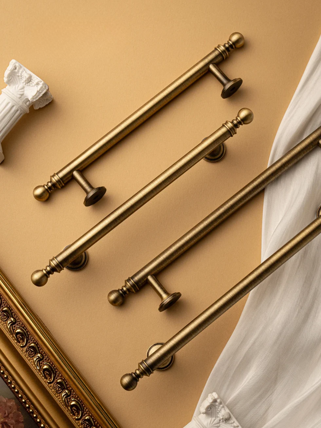 Set of gold cabinet handles on a beige background