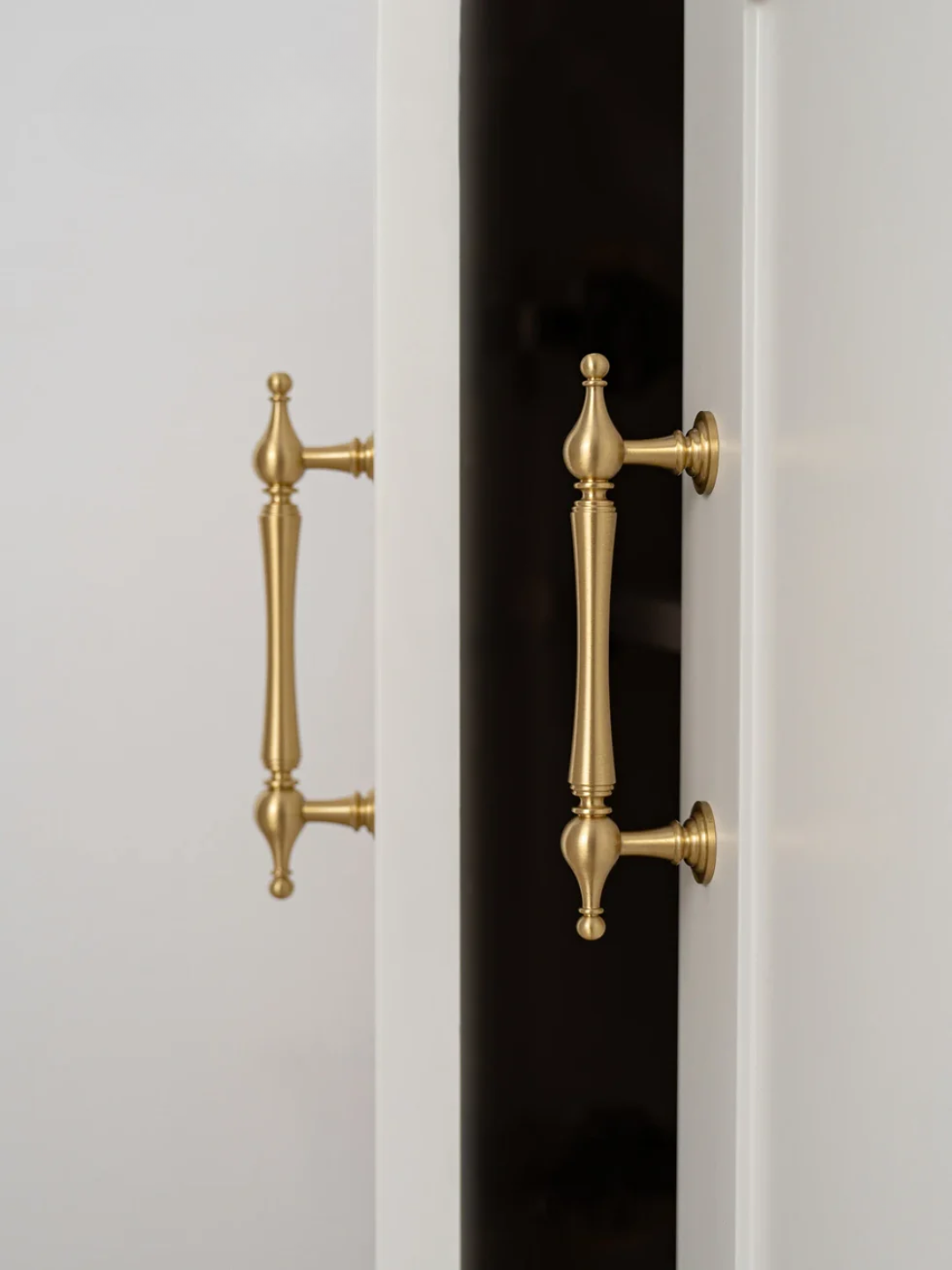 Close-up of a door with gold handles on a white and black background