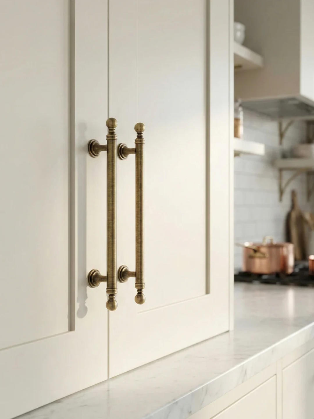 Close-up of a kitchen cabinet with brass handles in a modern kitchen setting.