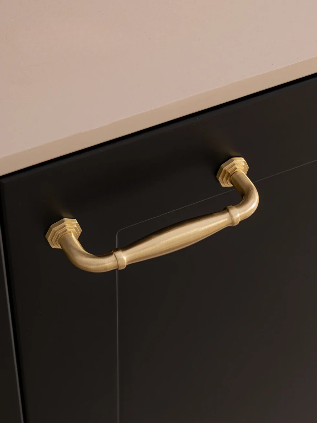 Black cabinet with a gold handle on a beige background