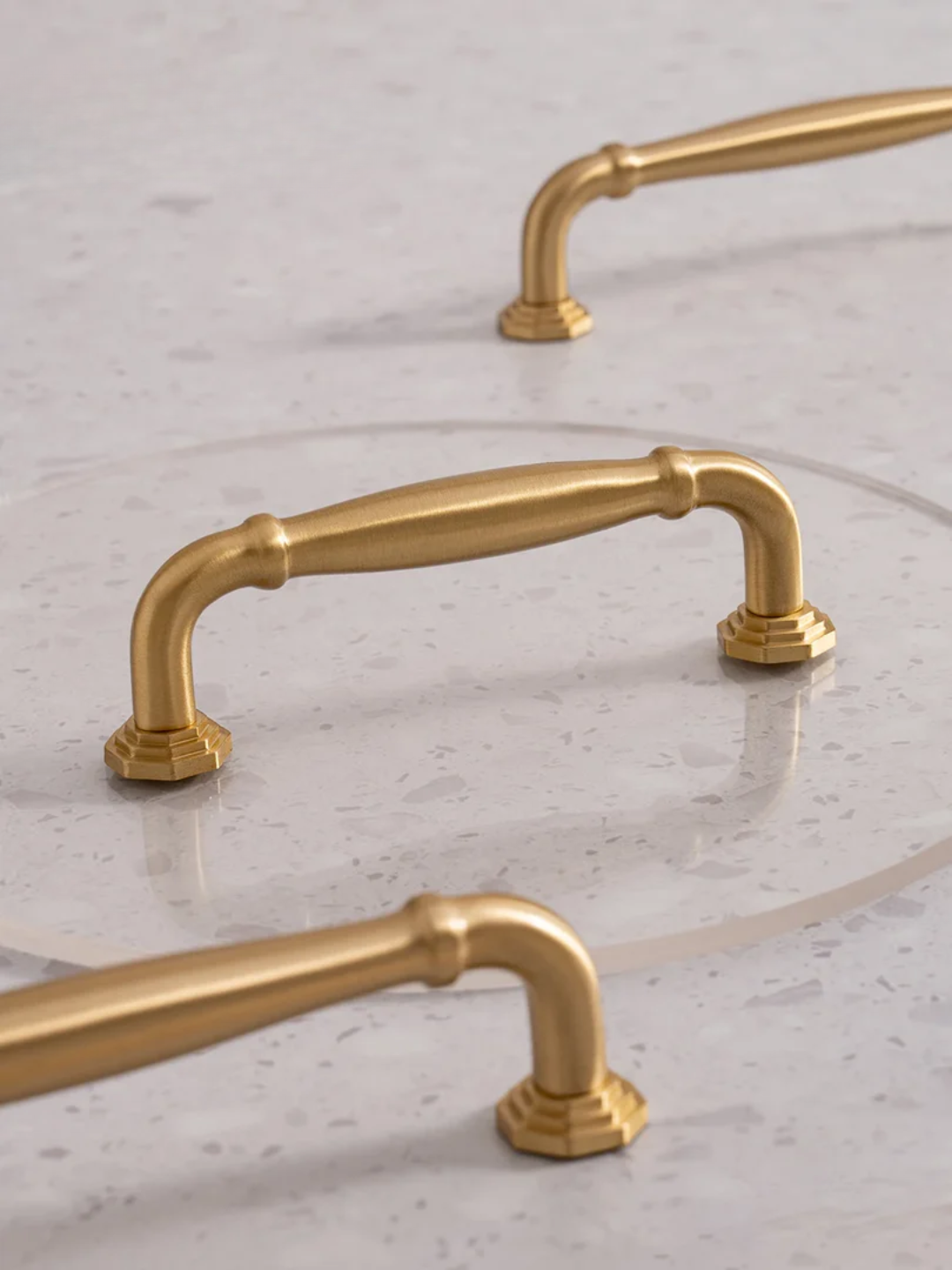 Gold cabinet handles on a marble surface