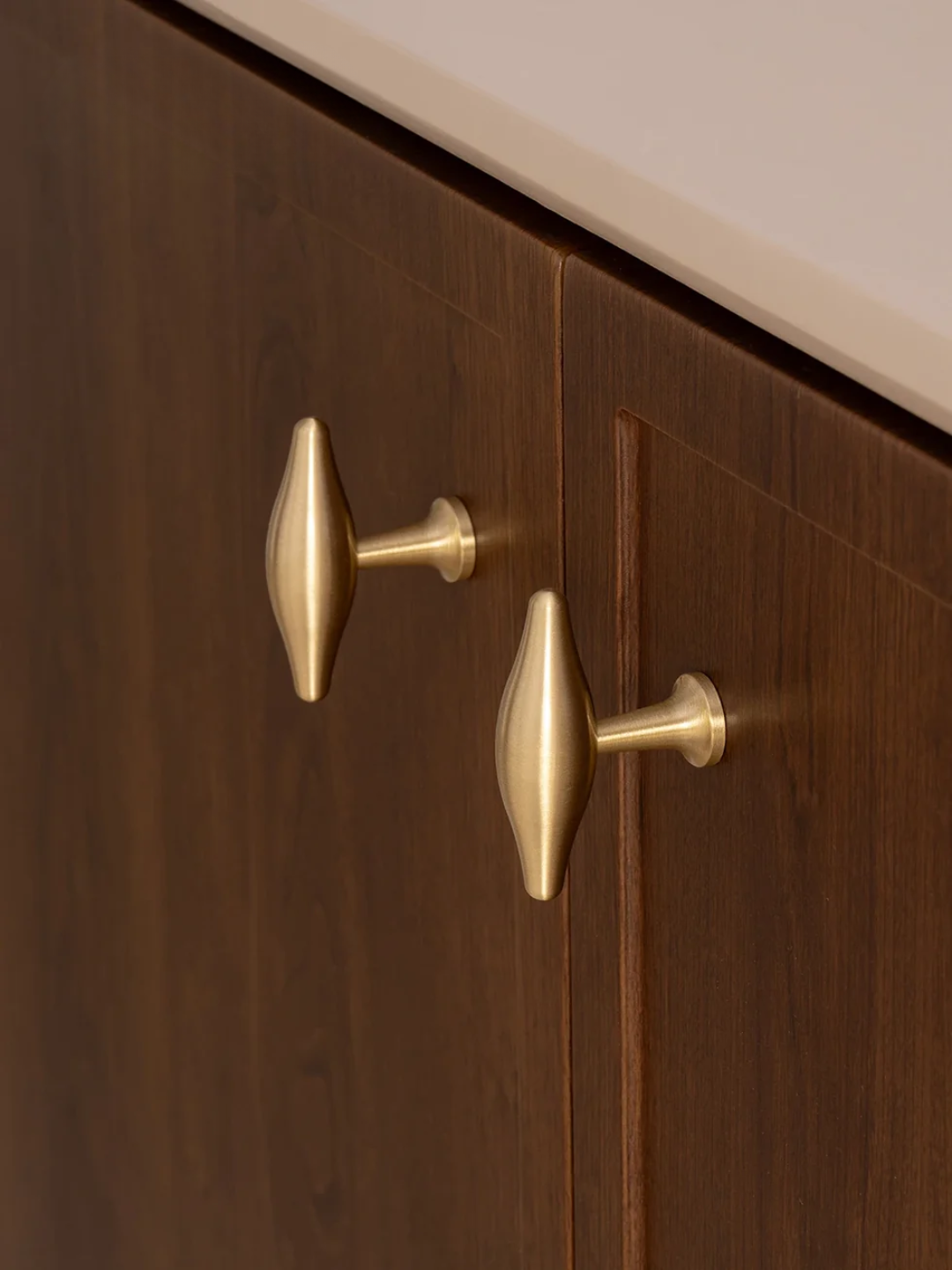Close-up of a wooden cabinet with gold knobs