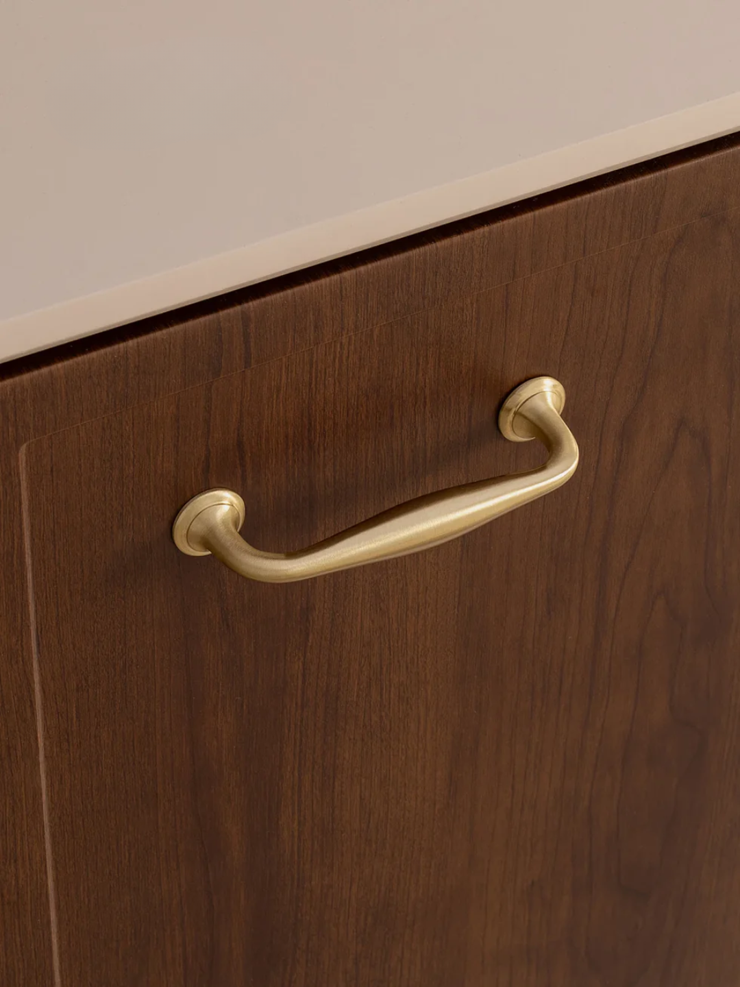 Wooden drawer with a gold handle on a neutral background