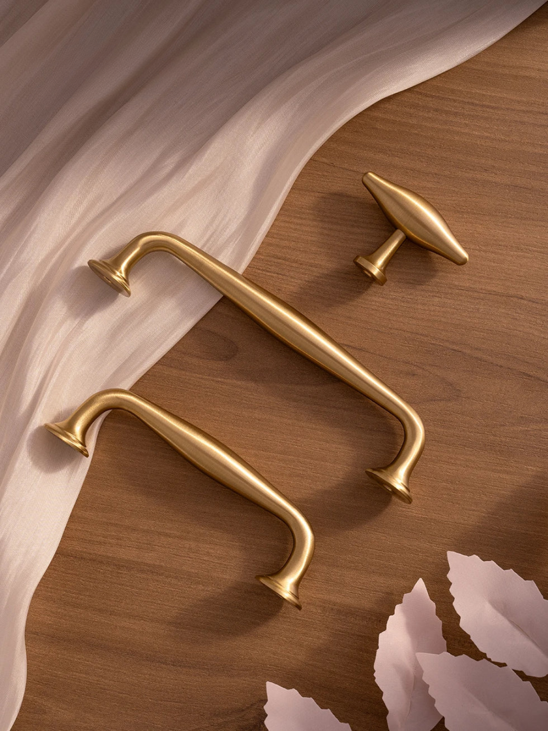 Gold handles on a wooden surface with fabric