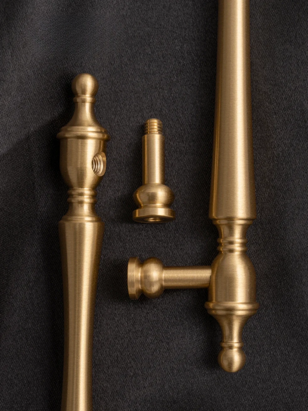 Set of gold-colored hardware components on a dark background