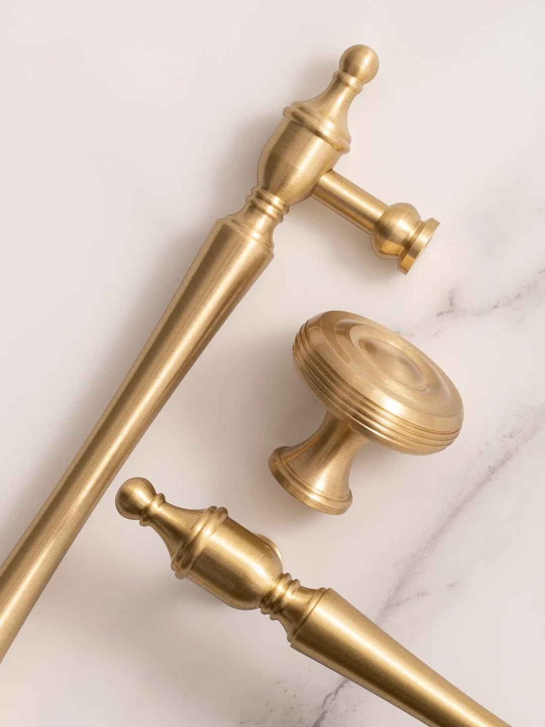 Gold curtain rods and finials on a marble surface
