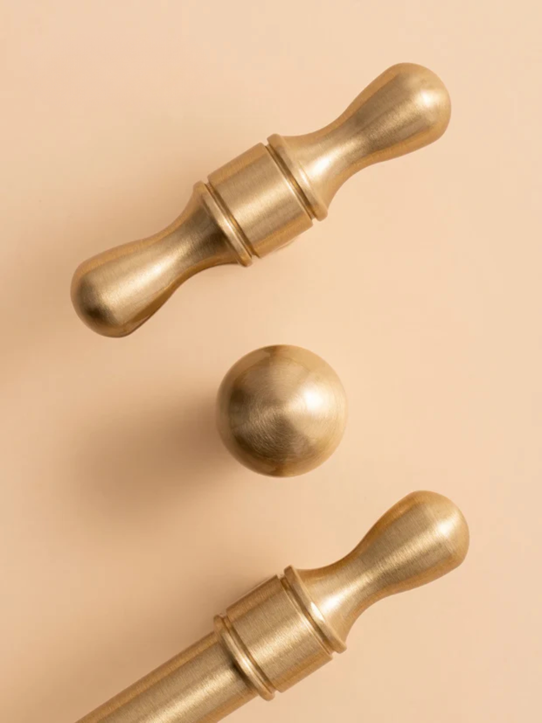 Three gold door knobs on a beige background