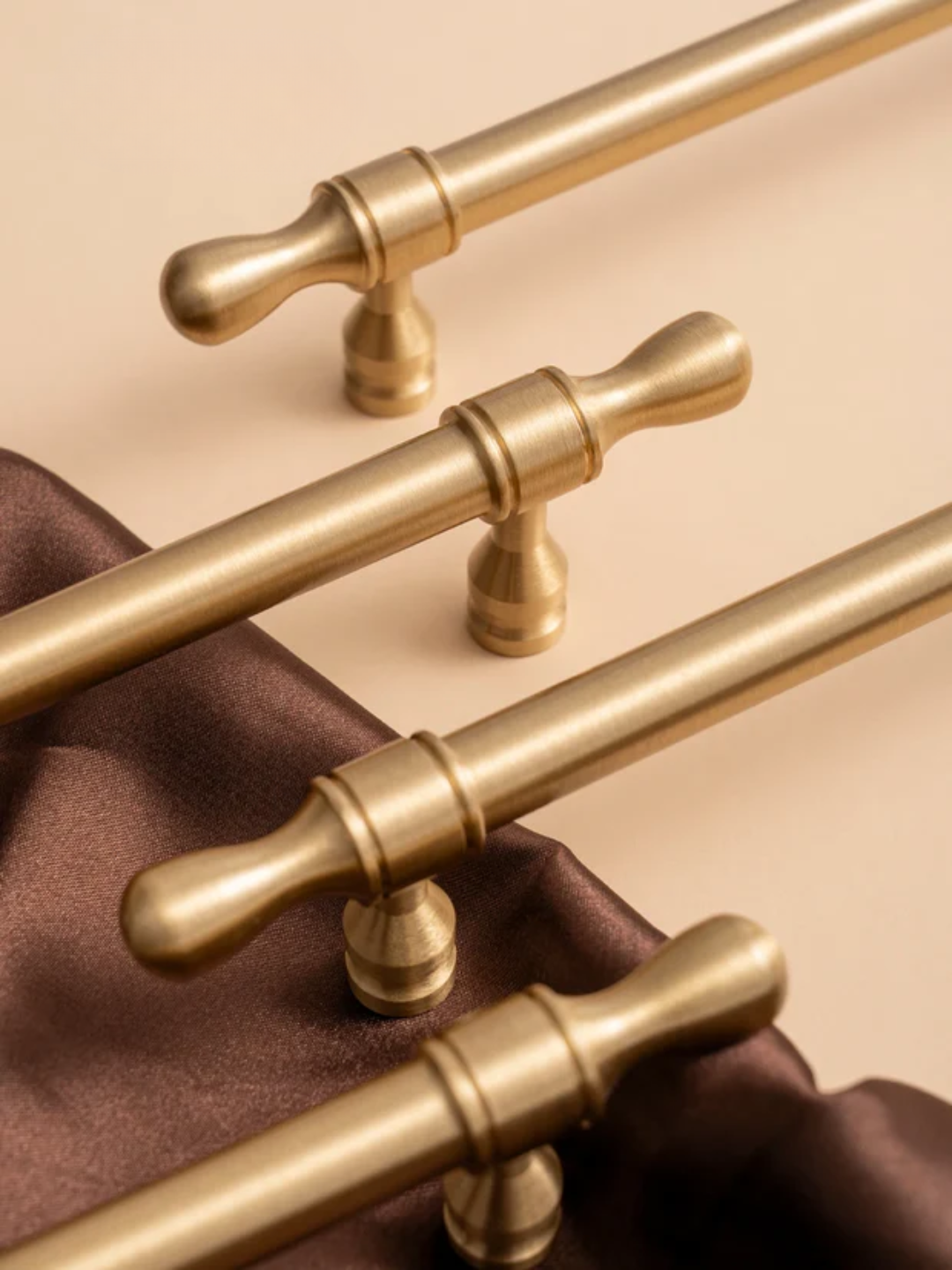 Gold cabinet handles on a beige background